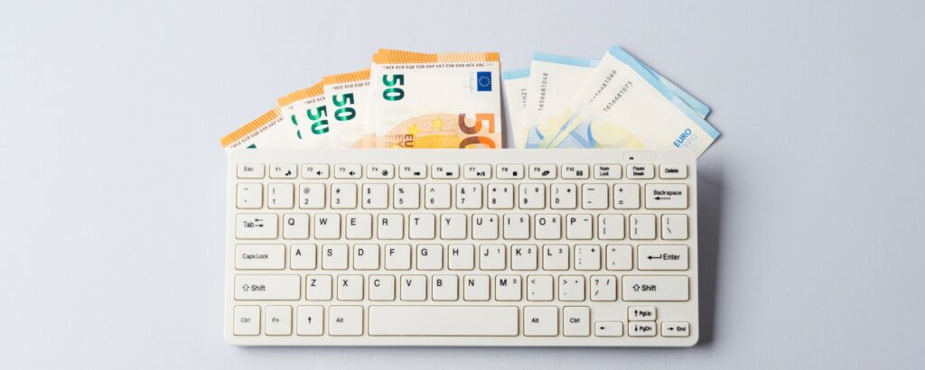 Notas de euro sob teclado, banca online, venda de produtos digitais